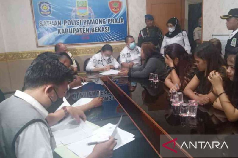 Caption Foto :  Petugas mendata pekerja seks komersial yang terjaring razia penyakit masyarakat di Kantor Satpol PP Kabupaten Bekasi, Jumat (16/9) dini hari.