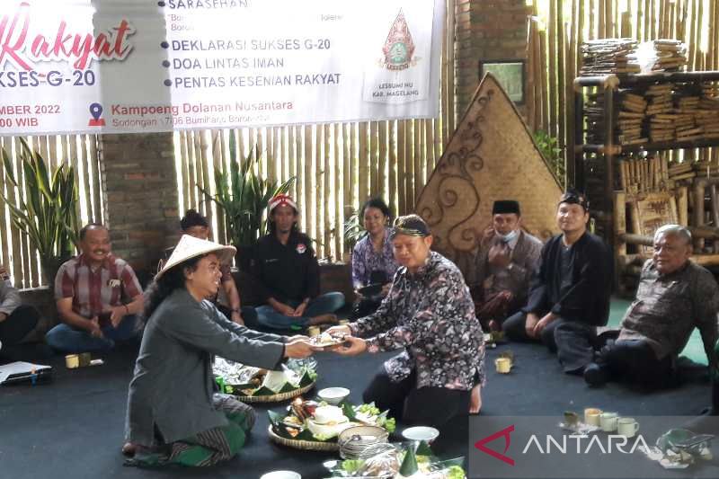 Camat Borobudur Subiyanto (kanan) memberikan potongan tumpeng kepada Koordinator Deklarasi Dukung Sukses G20 Borobudur Abbet Nugroho.
