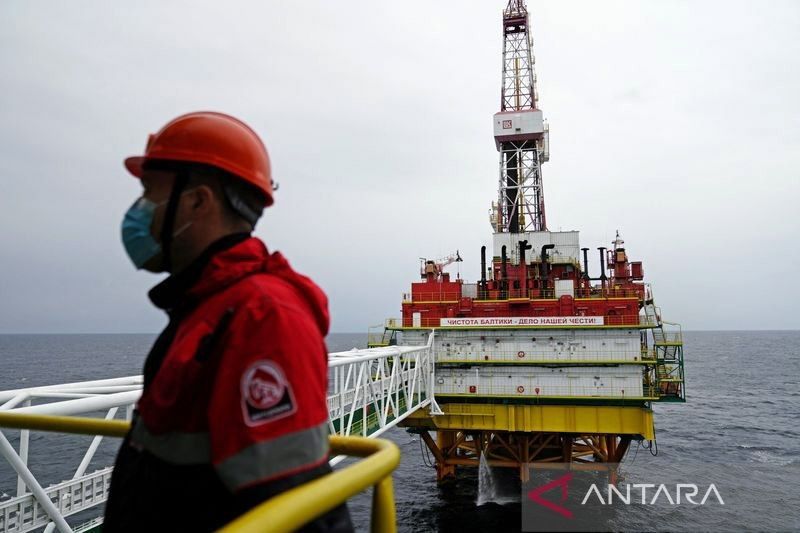 Seorang karyawan terlihat di anjungan minyak yang dioperasikan oleh perusahaan Lukoil di ladang minyak Kravtsovskoye di Laut Baltik, Rusia, Kamis (16/9/2021).