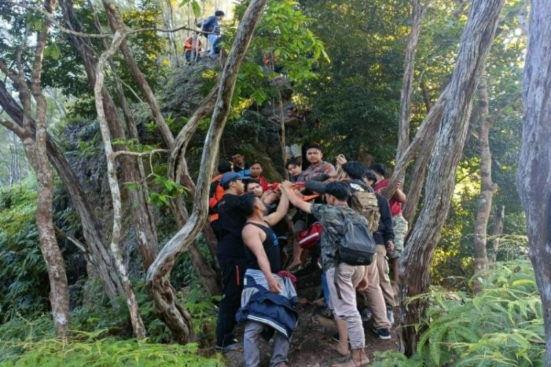 Caption Foto :  Personel kepolisian bersama warga mengevakuasi mahasiswa hilang di Bukit Popalia, Kecamatan Wolasi, Kabupaten Konawe Selatan, Sulawesi Tenggara, yang ditemukan selamat di jurang kedalaman 85 meter, Senin (26/9/2022)