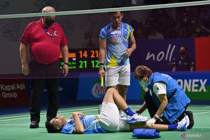 Caption Foto :  Petugas medis mengecek kondisi pebulu tangkis ganda putra Indonesia Yeremia Erich Yoche Yacob Rambitan yang jatuh dan berpasangan dengan Pramudya Kusumawardana saat melawan ganda putra Malaysia Aaron Chia/Soh Wooi Yik dalam laga Perempat F