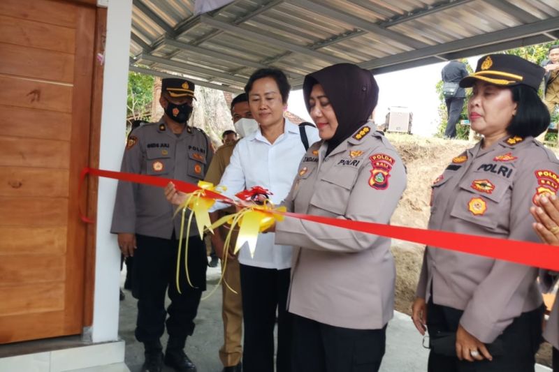 Caption Foto :  Kepala Bidang Keuangan Polda Bali Kombes Pol Endang Sri Wahyu Utami memotong pita pada saat penyerahan bantuan berupa rumah kepada masyarakat kurang mampu di Bali, Senin (5/9/2022).