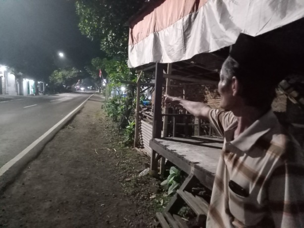 LOKASI KEJADIAN: Seorang warga menunjukkan lokasi pria yang menabrakkan diri ke truk yang melintas di Jalan Yos Sudarso, Kelurahan Kranjingan, Kecamatan Sumbersari, Jember. Lelaki tanpa identitas itu meninggal di tempat.