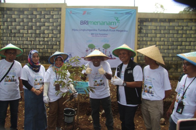 TANAM: Pimpinan KC BRI Lumajang Hendra Affandi Rambe bersama Kepala Desa Purwosono, Kecamatan Sumbersuko, Hendrik Dwi Martono, saat menanam bibit pohon buah dalam program BRI Menanam.