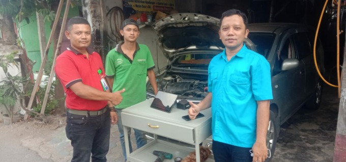 MEMUDAHKAN: Dosen Polije Ahmad Robiul Awal Udin, ST, MT (kanan), menyerahkan alat pemindai kerusakan mobil kepada Udy, pemilik bengkel di Desa Balung Kulon, Kecamatan Balung, Jember.