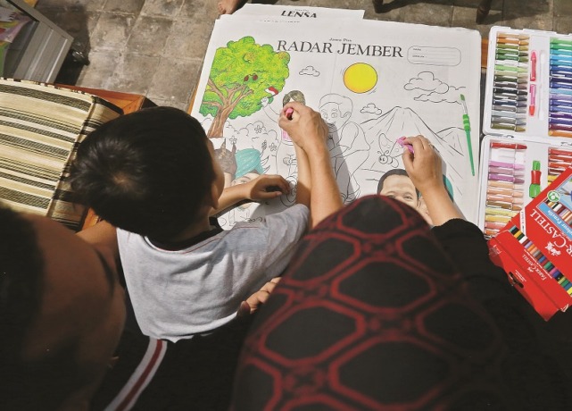 KOMPAK: Razqa ditemani ayah dan bundanya mewarnai koran Jawa Pos Radar Jember, di Patrang, kemarin (26/9).