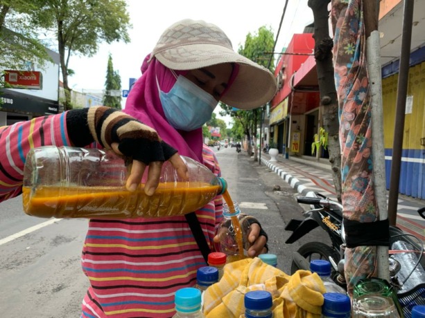 DITUANGKAN: Seorang pedagang jamu menuangkan ramuan herbal untuk dikonsumsi karena dipercaya memiliki segudang manfaat untuk imunitas tubuh.