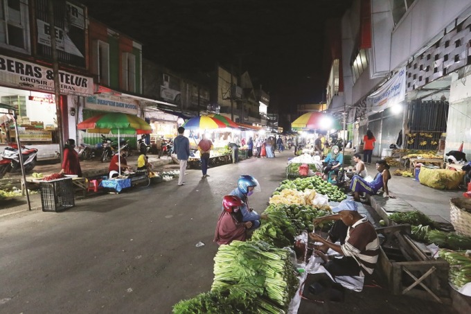 TETAP SEMANGAT: Sejumlah pedagang di jalan samping Pasar Tanjung berharap agar tidak turun hujan, kemarin.