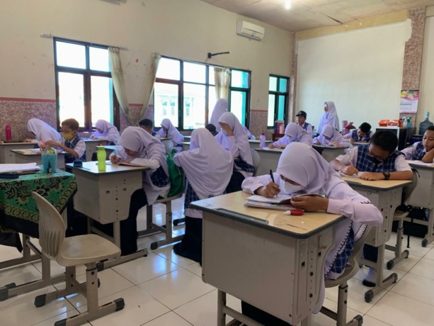 TEKUN: Siswa pada salah satu sekolah di Lumajang sedang mengerjakan tugas yang diberikan oleh gurunya. Dengan menggunakan seragam sekolah seperti hari biasanya.