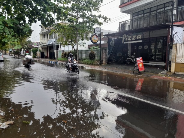 MENGGENANG: Pengendara roda dua melewati genangan air selepas hujan deras di salah satu wilayah kota Bondowoso.