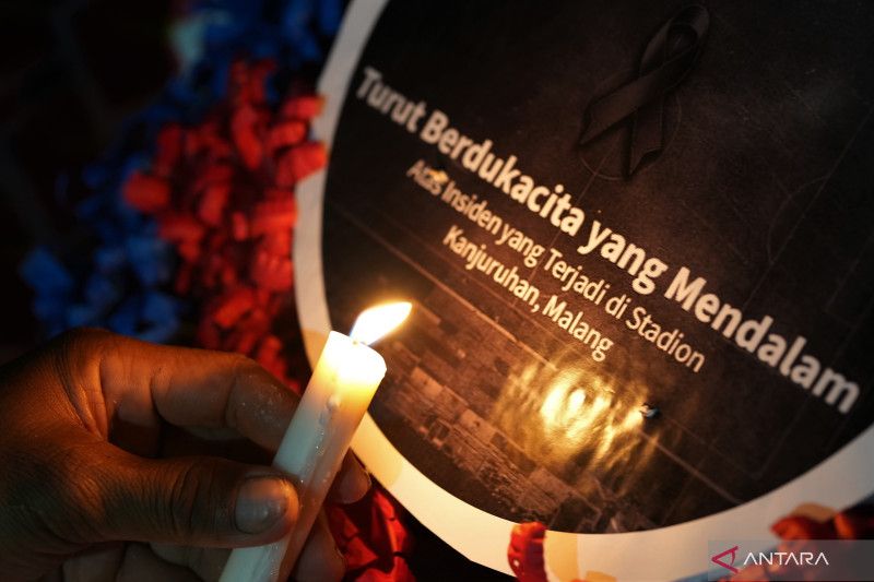 Caption Foto :  Warga menyalakan lilin saat doa bersama untuk para korban tragedi Kanjuruhan, di bawah tugu MTQ Square, Kendari, Sulawesi Tenggara, Selasa (4/10/22).