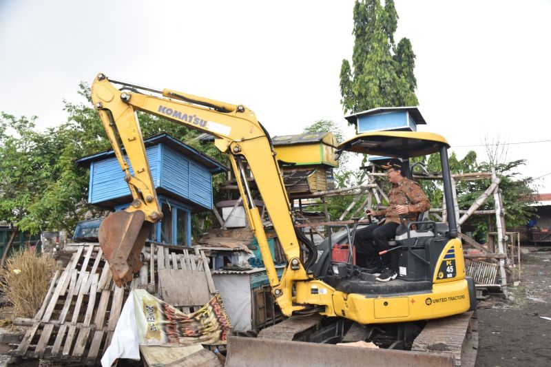 Caption foto : Bupati Sidoarjo Ahmad Muhdlor mengoperasikan alat berat saat proses pembersihan lahan relokasi masjid di Kabupaten Sidoarjo, Rabu (19/10)2022).