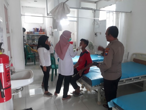 DAPAT PERAWATAN: Korban penganiayaan pelajar SMK Zainul Hasan, Desa Balung Lor, saat dilakukan pemeriksaan oleh petugas kesehatan.