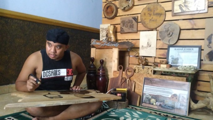 ARTISTIK: Thoni, 29, seniman lukis bakar warga Desa/Kecamatan Arjasa, Jember.