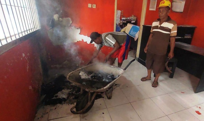 JADI ABU: Dua pekerja membersihkan sisa-sisa arsip LPJ dan SPJ yang dibakar OTK. Polisi sedang menyelidiki kasus sabotase dokumen pertanggungjawaban Pemdes Wonojati tersebut.