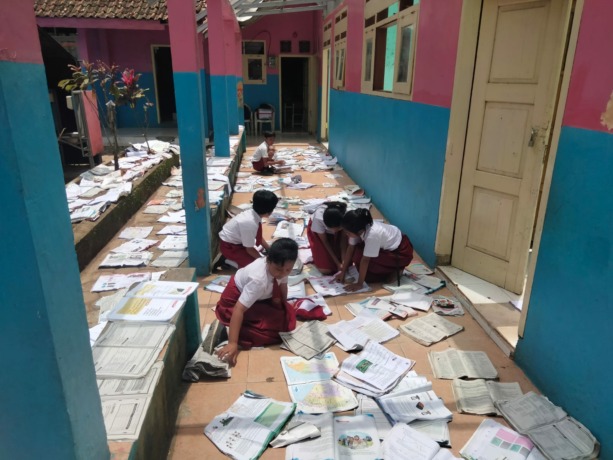 RUSAK: Ratusan buku baru yang belum digunakan dijemur karena terkena hujan, setelah empat kelas SDN Gelang 07 ambruk.