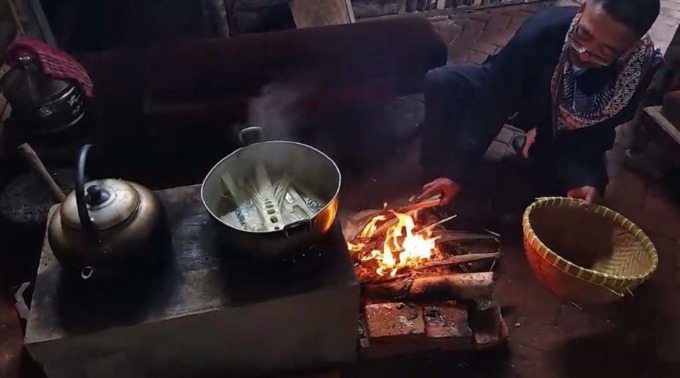 DIGANTUNG: Salah seorang warga sedang mengasap rebung dengan proses yang cukup lama hingga menciptakan rasa dan aroma yang khas.