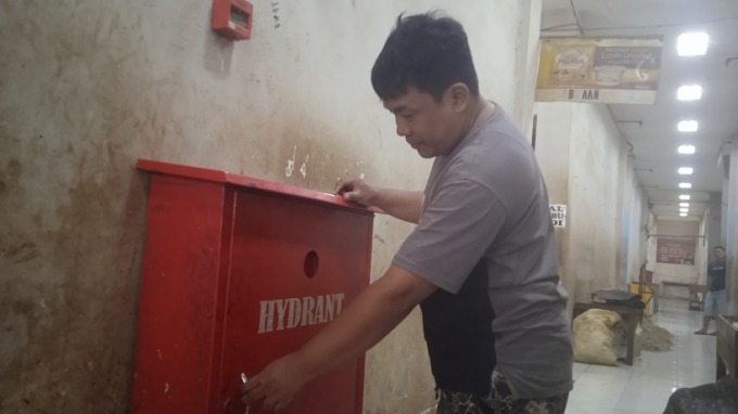 MENUNJUKKAN: Penjual daging sapi, Moh Kholil, menunjukkan hidran di Pasar Induk Bondowoso, kemarin.