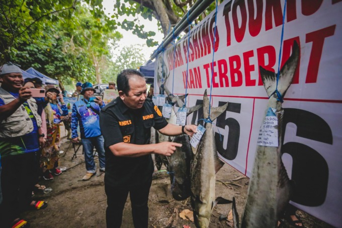 TAKJUB: Bupati Hendy Siswanto menunjukkan deretan ikan yang berhasil dipancing dalam lomba JFT di Papuma.