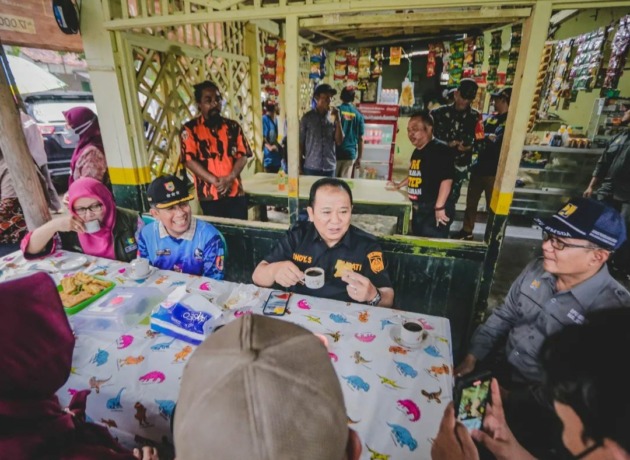 BERSANTAI: Bupati Jember Hendy Siswanto saat menikmati segelas kopi hitam di warung pinggir sawah, Minggu (13/11). Dalam kesempatan tersebut bupati juga dan bercengkerama bersama warga Desa Sumberejo, Kecamatan Ambulu.