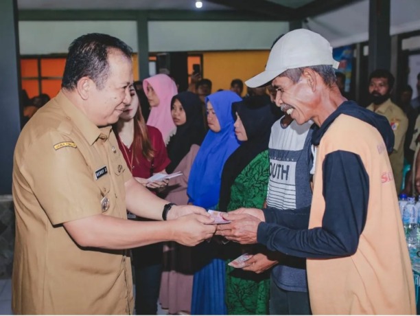 BERI TALI ASIH: Bupati Jember Hendy Siswanto saat membagikan BLT kepada warga, kemarin pagi (14/11), di Balai Desa Panduman, Kecamatan Jelbuk.