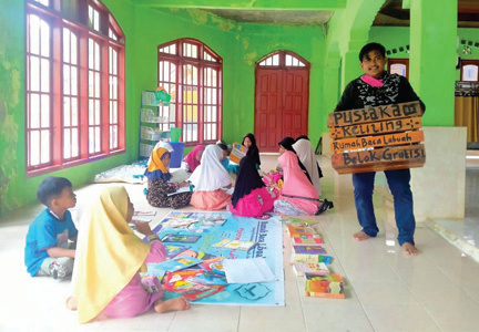 Jafri Ayub (kanan) setiap hari memiliki aktivitas berkeliling mendatangi anak-anak untuk dekat dengan buku bacaan, hal ini sengaja dilakukan oleh pria tersebutdemi ikut mencerdaskan anak bangsa.