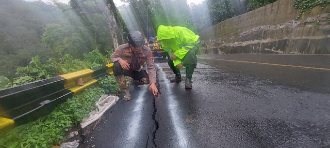 ASAL-ASALAN: Kapolsek Silo AKP Tanto saat melihat retakan jalan nasional di KM 39, yang baru ditutup dengan aspal/ Jumai for Radar Jember