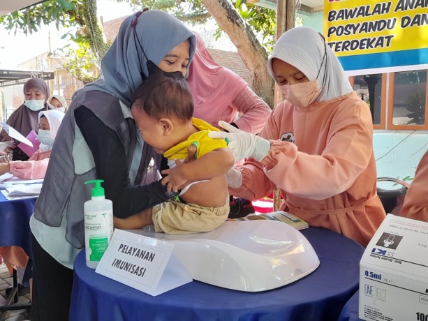 TEGANG: Salah seorang bayi ketika mendapatkan suntikan imunisasi. Ternyata AKI/AKB di Bondowoso masih tinggi.