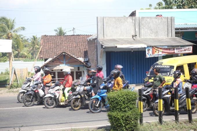 TAK SABAR: Beberapa pengendara berhenti di depan palang pintu perlintasan di Jalan Bondowoso-Jember, Kelurahan Baratan, Kecamatan Patrang.