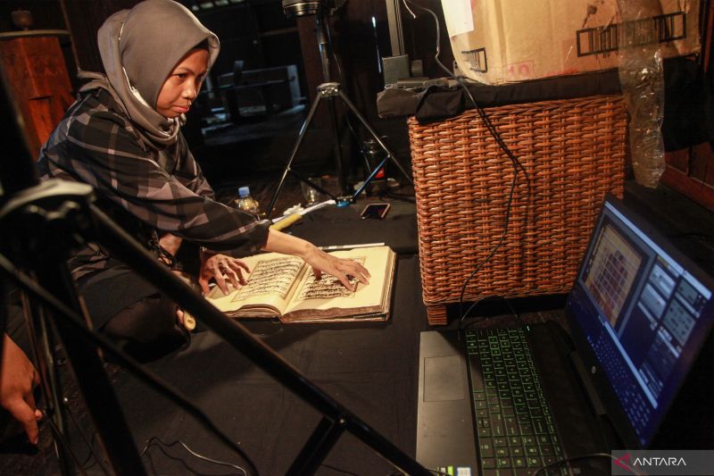 Petugas Dreamsea memotret Al Quran peninggalan Sultan Mangkubumi saat melakukan proses digitalisasi di Istana Mangkubumi, Pangkalan Bun, Kotawaringin Barat, Kalimantan Tengah, Minggu (6/11/2022). Badan Riset dan Inovasi Nasional (BRIN) bersama Balai Peles