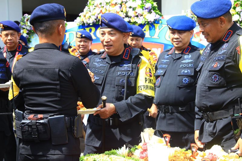 Kapolri Jenderal Pol. Listyo Sigit Prabowo didampingi Dankorps Brimob Komjen Pol. Anang Revandoko memberikan potongan tumpeng kepada salah satu anggota Brimob dalam acara peringatan HUT ke-77 Brimob di Bali, Senin (14/11/2022).