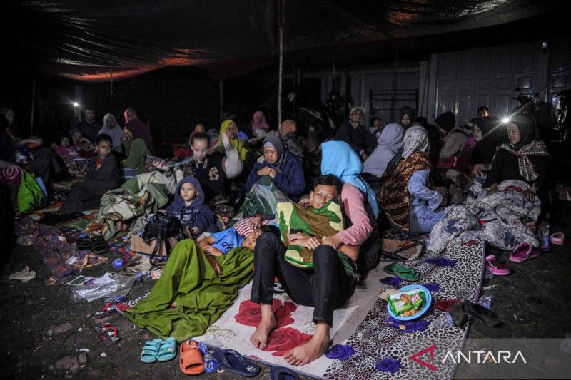 Warga mengungsi di halaman rumah mengantisipasi adanya gempa susulan di Kampung Cijedil, Kabupaten Cianjur, Jawa Barat, Senin (21/11/2022).