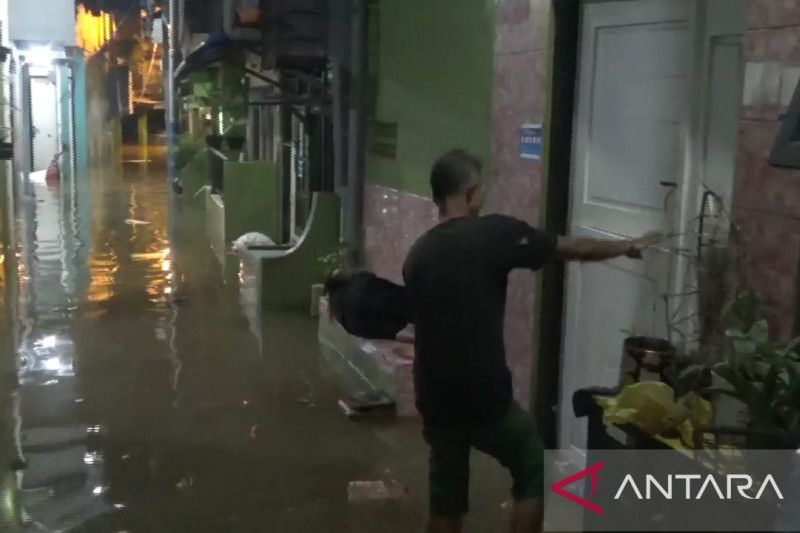 Warga beraktivitas dalam kondisi banjir di RW 04 Kebon Pala, Jakarta, Senin (14/11/2022).