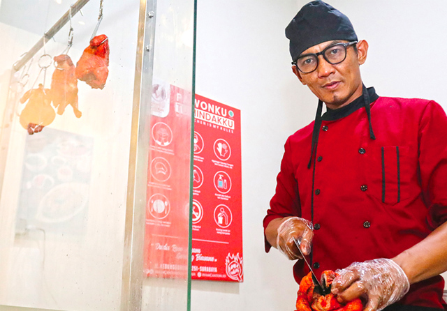 Eko Sulistiyo memotong ayam canton, salah satu menu andalan di kedai Ayam Canton Soerabaja. Kini usaha pria tersebut semakin dikenal orang, karena Eko mampu menjual kuliner menggugah selera.
