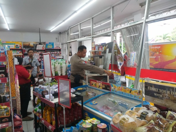 OLAH TKP: Anggota polisi memeriksa kondisi gerai Alfamart di Desa Sumberjati, Kecamatan Silo. Toko waralaba itu rusak setelah tertabrak truk, Rabu (2/11).