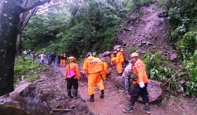 JALUR TERPUTUS: Petugas gabungan bersiaga di lokasi longsor Desa Pace, Kecamatan Silo, Jember. Mereka membutuhkan alat berat untuk membersihkan material longsor.