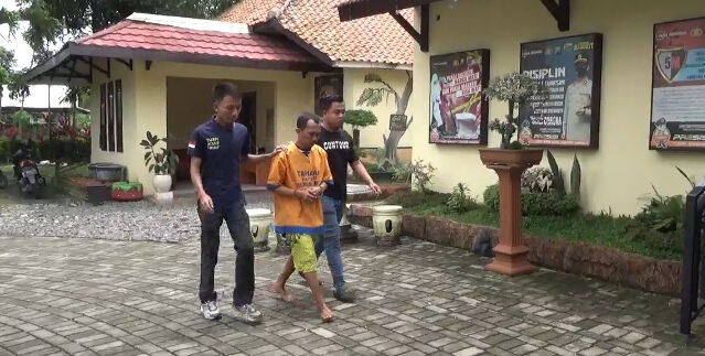 TAK BERKUTIK: Anggota Polsek Sumberbaru menggelandang pelaku pencabulan terhadap anak tirinya. 