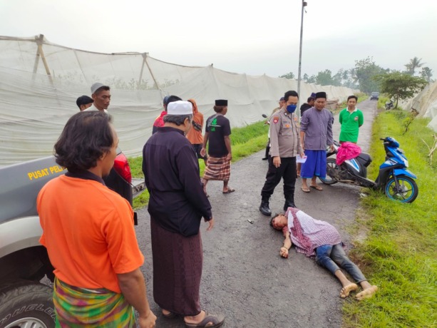 TERGELETAK: Korban saat awal pertama ditemukan oleh warga. Pemuda 18 tahun tersebut tak sadarkan diri di areal persawahan Desa Gumelar, Kecamatan Balung, Jember, Jumat (25/11) pagi.