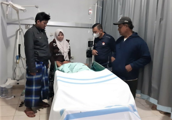 DIRAWAT: Keluarga korban dan kepala dusun saat menjenguk Ahmadi, korban yang ditemukan babak belur di saluran irigasi di area persawahan Desa Gumelar, Kecamatan Balung, Jember, hari ini (25/11).