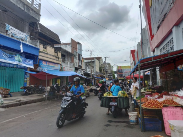 PADAT: Kendaraan bermotor saat melewati Pasar Tanjung yang dipenuhi pedagang di bahu jalan, kemarin (6/11) sekitar pukul 14.00. Sayangnya, peraturan jam pedagang saat ini tidak ditaati lagi.