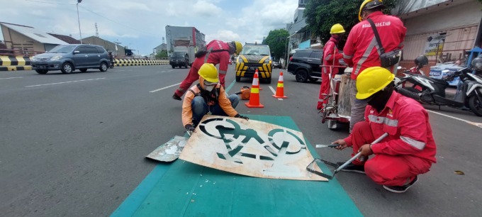 TERUS DIBERI TANDA: Sejumlah pekerja ketika membuat tanda jalur khusus sepeda. Kini di jalan nasional area kota Jember terdapat jalur berwarna hijau khusus sepeda.