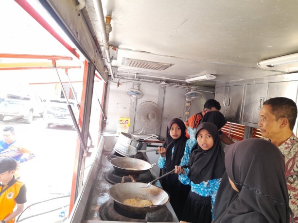 TELATEN: Sejumlah siswa ketika memasak di dalam truk BPBD.