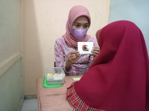 BELAJAR: Guru pendamping anak berkebutuhan khusus sedang mengenalkan huruf di TK Cahaya Nurani, Kelurahan Sumbersari, Kecamatan Sumbersari.