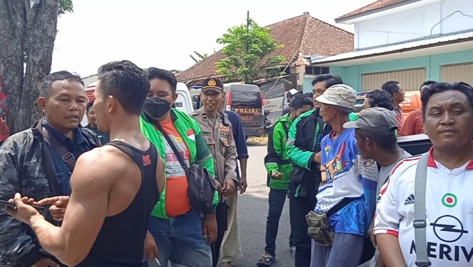 PENASARAN: Sejumlah masyarakat yang menunggu di depan gang saat rekontruksi kasus pembunuhan driver ojol.