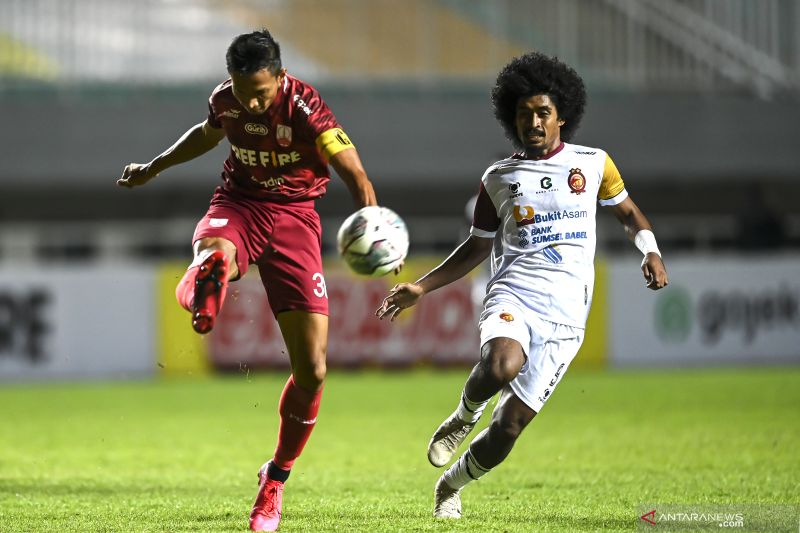 Foto arsip - Pesepak bola Persis Solo Eky Taufik (kiri) menendang bola dari pesepak bola Sriwijaya FC Sunawan Rusni (kanan) dalam lanjutan babak delapan besar Liga 2 di Stadion Pakansari, Kabupaten Bogor, Jawa Barat, Minggu (19/12/2021). . ANTARA FOTO/M R