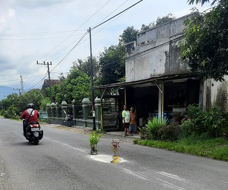 TAMBAL JALAN: Jalanan sekitar Desa Lengkong, Kecamatan Mumbulsari, yang berlubang ditambal oleh masyarakat sekitar.