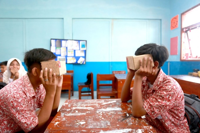 MENARIK: Dua siswa SDN Tegal Besar 04 yang sedang menggunakan VR sederhana berbahan dasar kardus bekas. VR tersebut digunakan untuk mempelajari tentang tata surya.