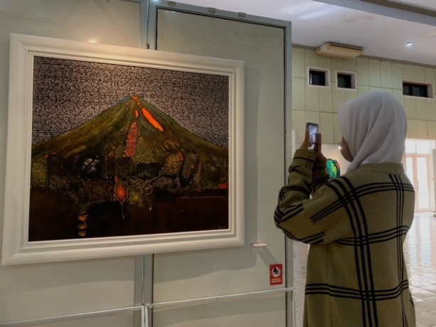 KAGUM: Seorang pelajar SMA di Lumajang terpesona melihat kecantikan lukisan karya berbagai perupa di Jawa Timur. Tak terkecuali dari Lumajang.