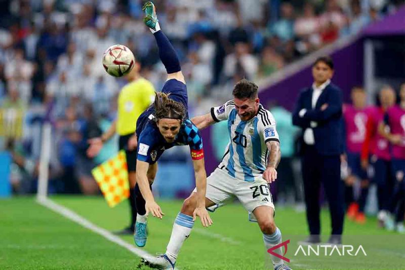 Pemain Kroasia Luka Modric berebut bola dengan pemain Argentina Alexis Mac Allister pada semifinal Piala Dunia 2022 di Lusail Stadium, Lusail, Qatar, Selasa (13/12/2022). Argentina melangkah ke final Piala Dunia 2022 setelah mengandaskan Kroasia 3-0.