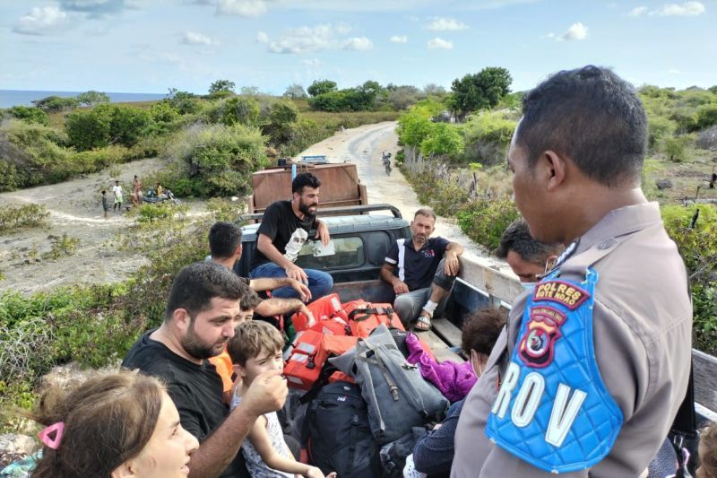 Aparat kepolisian Rote Ndao mengawal sejumlah imigran asal Irak yang terdampar di perairan Rote Ndao, NTT.